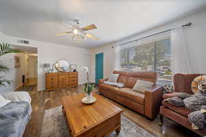 Living area featuring wood-type flooring and ceiling fan