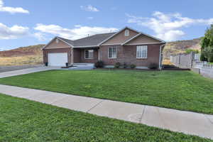 Ranch-style home featuring brick siding, concrete driveway, and a garage