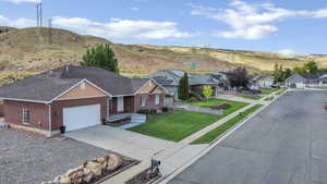 Ranch-style house featuring driveway, a mountain view, brick siding, an attached garage, and a residential view