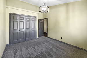 Unfurnished bedroom with carpet and baseboards
