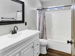 Full bath with vanity, wood finished floors, and shower / tub combo with curtain