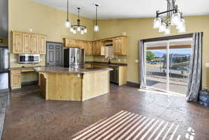 Kitchen with a chandelier, light brown cabinetry, stainless steel appliances, a center island, and high vaulted ceiling