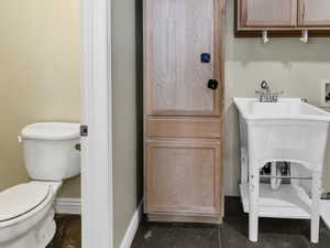 Half bathroom featuring toilet and baseboards