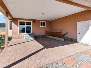 Entrance to property with stucco siding and a patio area