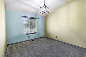 Empty room with carpet and lofted ceiling