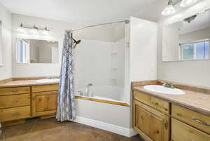 Bathroom with shower / tub combo, vanity, and tile patterned floors