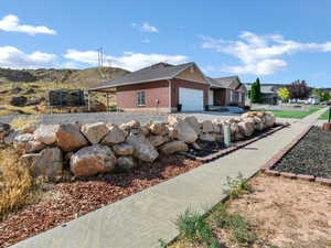View of property exterior with a trampoline, an attached garage, and brick siding