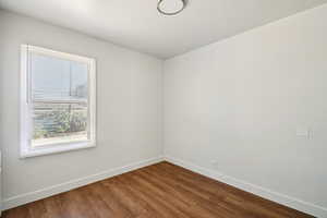 Empty room featuring baseboards and wood finished floors