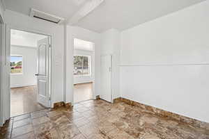 Spare room featuring attic access and stone finish flooring