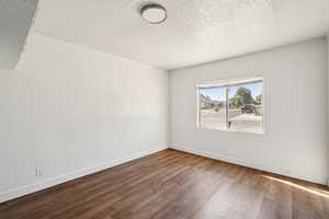 Spare room featuring a textured ceiling and wood finished floors