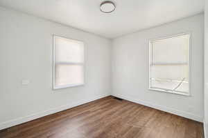 Spare room featuring dark wood finished floors and plenty of natural light