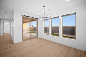 Unfurnished dining area with a chandelier, recessed lighting, and light wood-type flooring