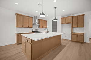 Kitchen with backsplash, brown cabinets, light wood finished floors, pendant lighting, and recessed lighting