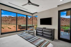 Carpeted bedroom featuring a ceiling fan and access to exterior