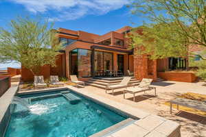 Back of house featuring a patio, stucco siding, an outdoor pool, and stone siding