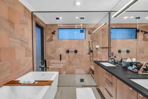 Full bathroom with tile walls, a soaking tub, double vanity, a shower stall, and tile patterned floors