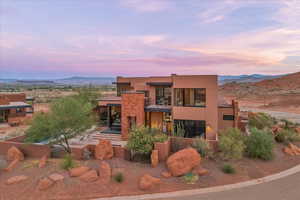 Rear view of property featuring a mountain view, stucco siding, and a balcony