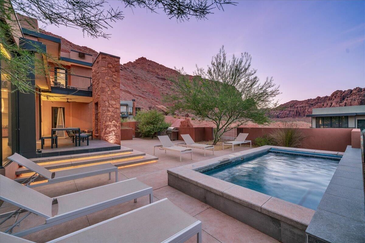 Pool at dusk with a patio area and outdoor dining area