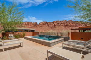 View of pool with a patio area, an outdoor hot tub, and a mountain view