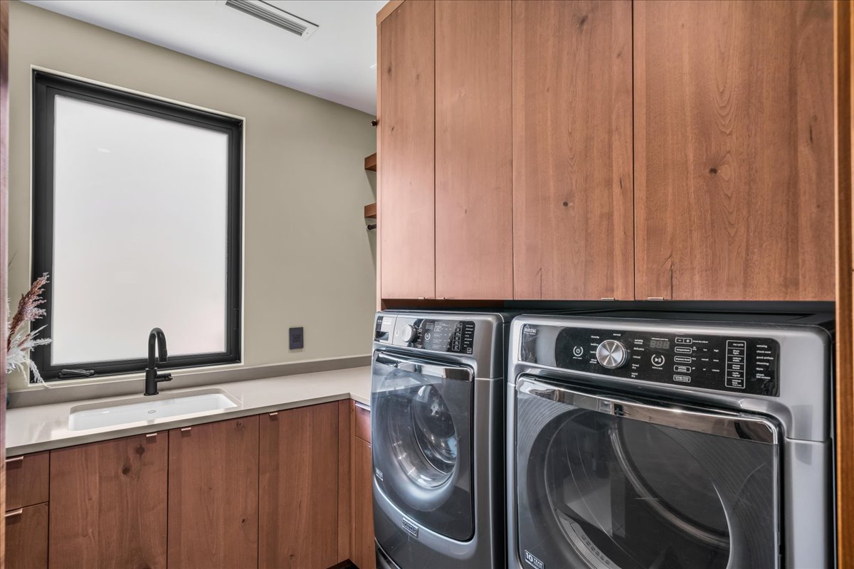 Laundry area with cabinet space and washer and clothes dryer