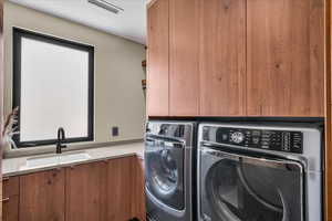 Laundry area with cabinet space and washer and clothes dryer