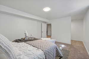 Bedroom featuring carpet floors and baseboards