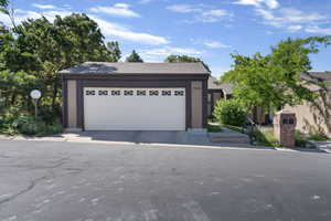 View of front of house featuring a garage and roof with shingles