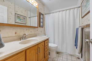 Full bathroom with vanity, tile patterned flooring, and wallpapered walls