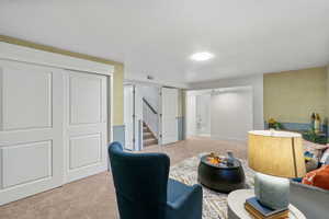 Living area featuring light colored carpet and stairway