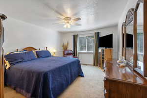 Huge Primary Bedroom with light colored carpet, a textured ceiling, and ceiling fan