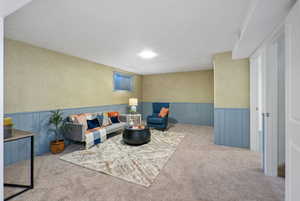 Living area featuring wainscoting, wallpapered walls, and carpet
