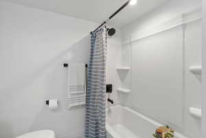 Full Bathroom with shower / bath combination with curtain and toilet