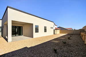 Rear view of property featuring a fenced backyard, a patio, and stucco siding