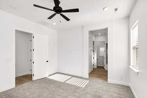Unfurnished bedroom with multiple windows, a ceiling fan, light colored carpet, recessed lighting, and connected bathroom
