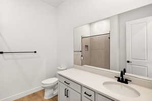 Full bath featuring light wood-style flooring, vanity, and tiled shower