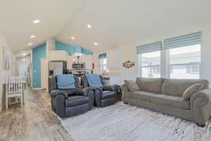 Living area featuring vaulted ceiling and light wood finished floors