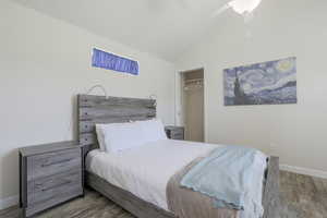 Bedroom featuring vaulted ceiling, wood finished floors, ceiling fan, and a closet