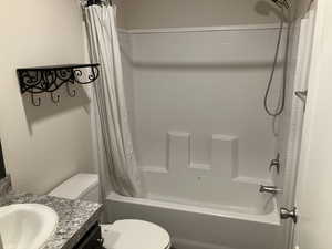 Bathroom featuring vanity and shower / bathtub combination with curtain