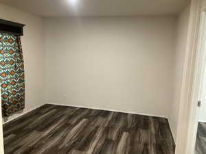 Unfurnished room with dark wood finished floors and baseboards