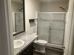 Bathroom with a shower stall, vanity, and wood finished floors