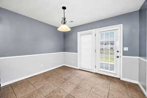 Unfurnished dining area with baseboards and tile patterned floors