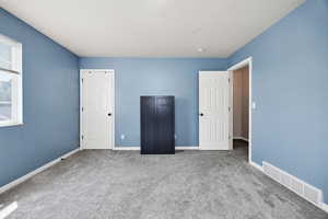 Unfurnished bedroom featuring carpet and baseboards