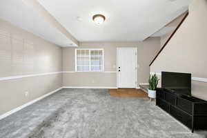 Unfurnished living room featuring carpet and tile patterned floors