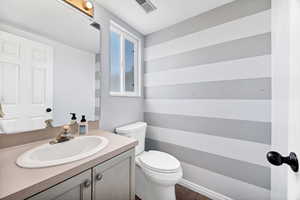 Half bath featuring toilet and vanity