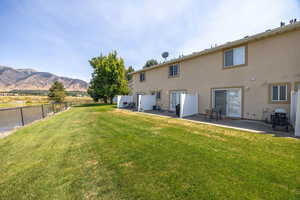 Rear view of property with stucco siding, a patio area, and a mountain view