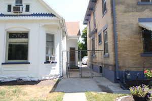View of side of property with brick siding and a gate