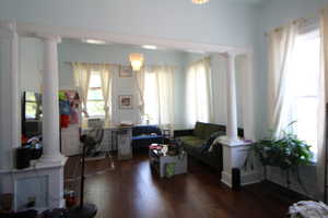 753-Living area featuring ornate columns and dark wood-style floors
