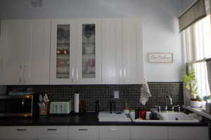 745-Kitchen featuring white cabinets, stainless steel microwave, and glass insert cabinets
