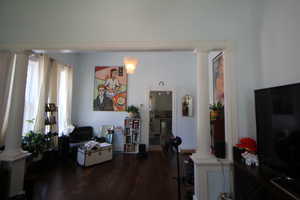 L743-iving room with decorative columns and wood finished floors