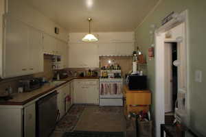 743-Kitchen with tile counters, white range with gas stovetop, dishwasher, and white cabinetry